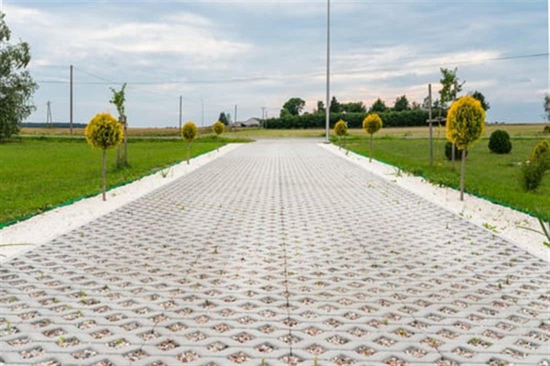 Long finished concrete driveway running through a landscaped residential property