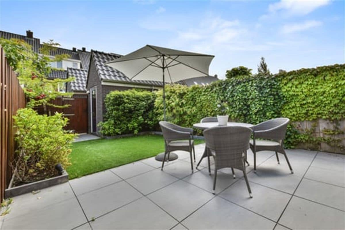 Finished concrete patio with outdoor furniture behind a Southern California home