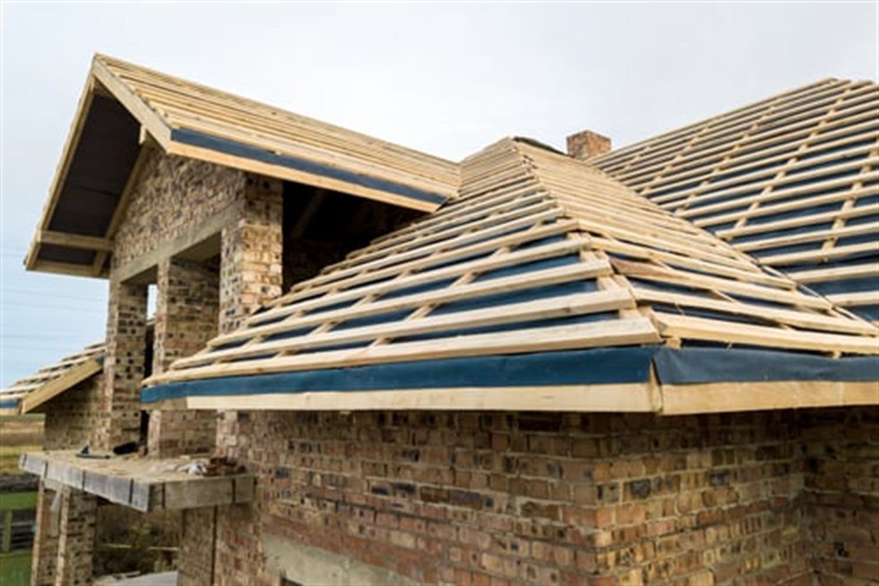 Residential construction project with new framing and roof structure by Concecret Construction Corp